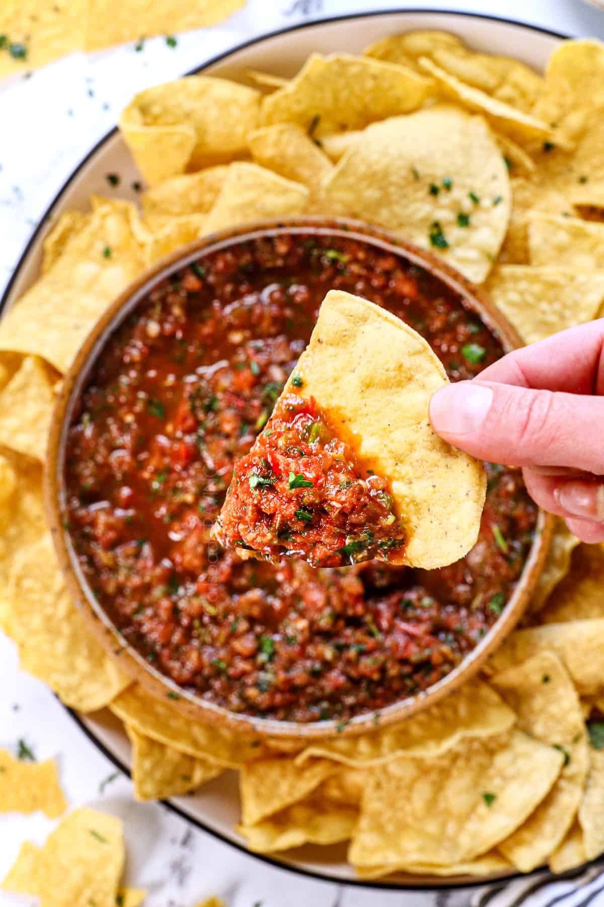 holding up chip with salsa on it to show the fresh salsa recipe 