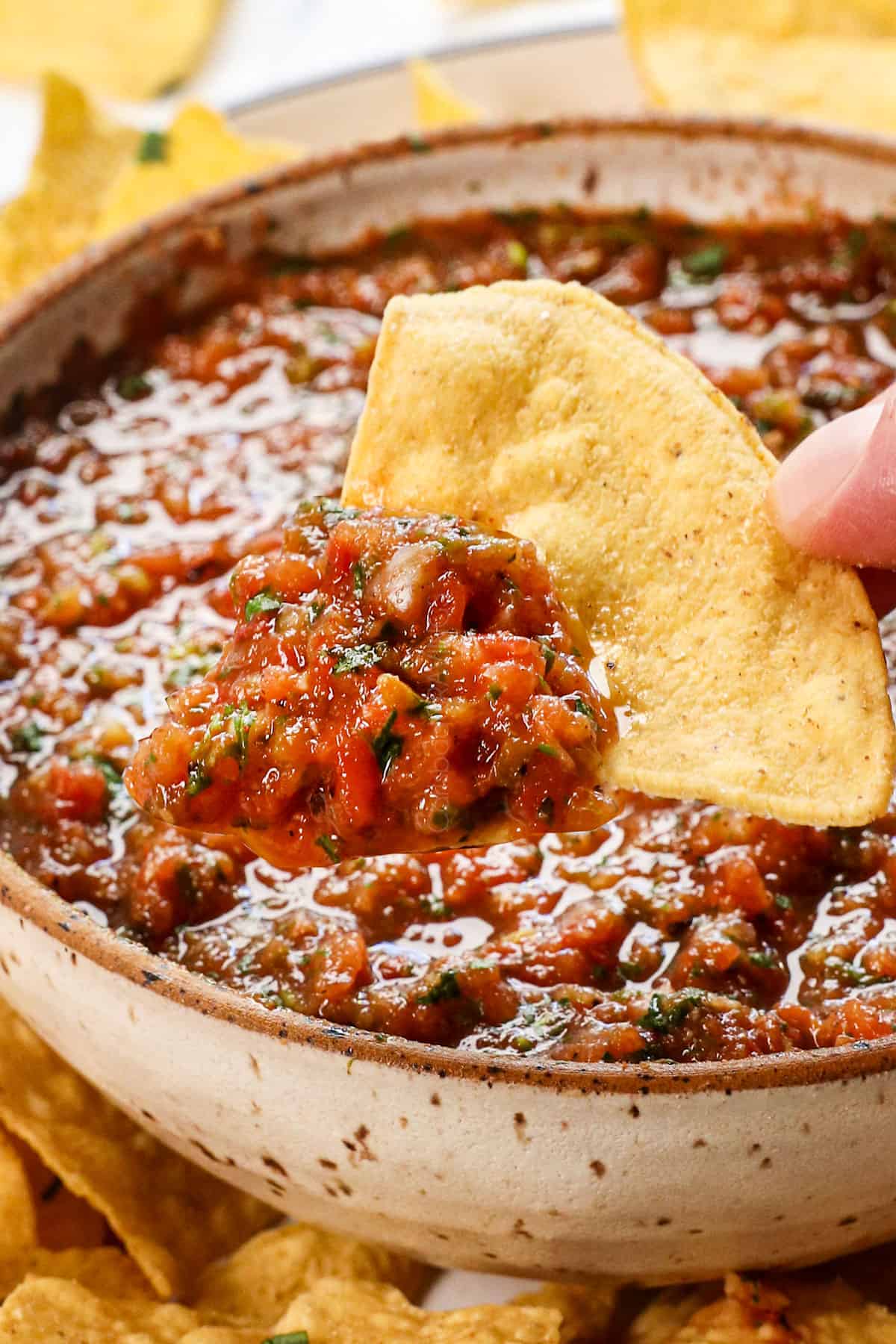 dipping a chip in the best homemade salsa recipe