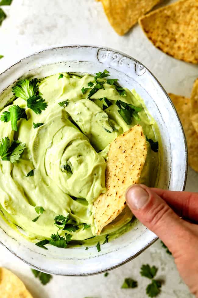 a chip dipping into easy avocado crema