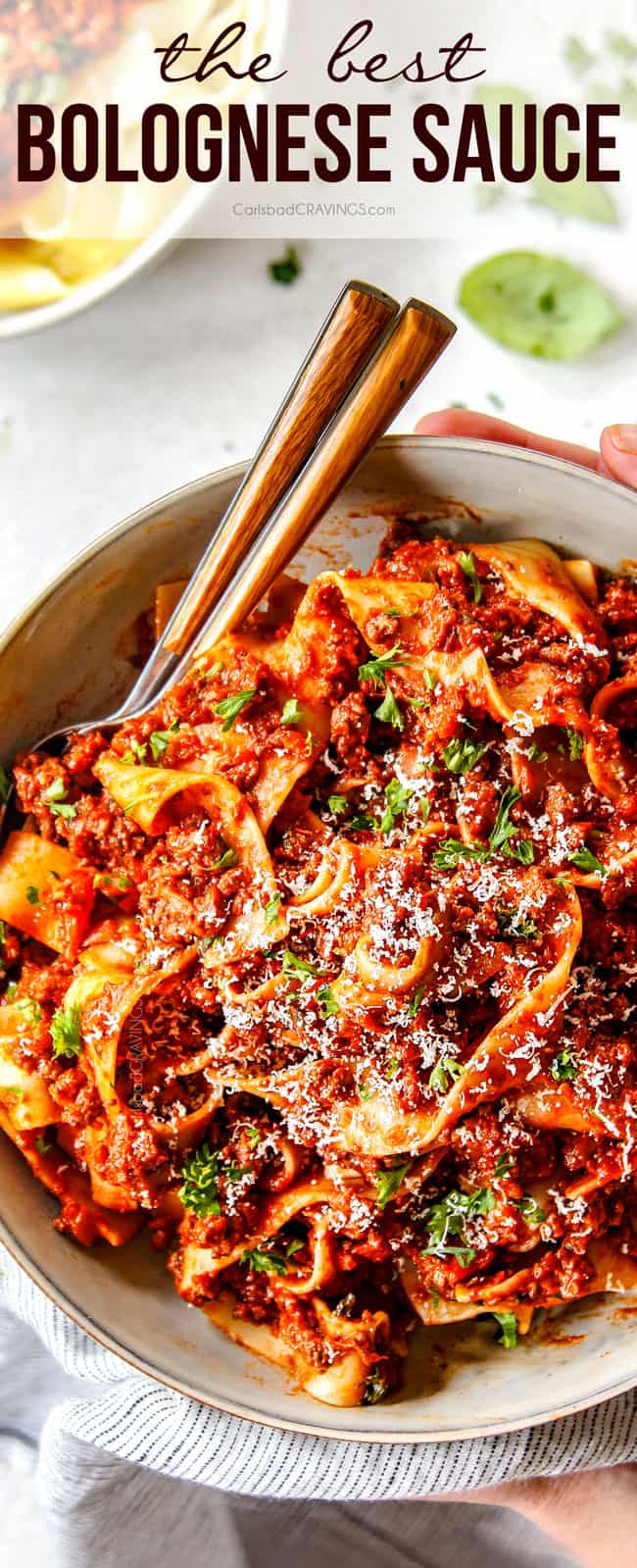 two hands holding a bowl of Bolognese