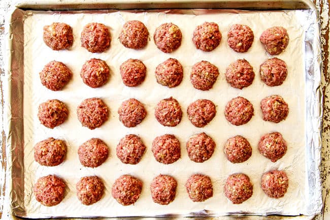 showing how to make cranberry meatballs by lining them evenly on a foil lined baking sheet