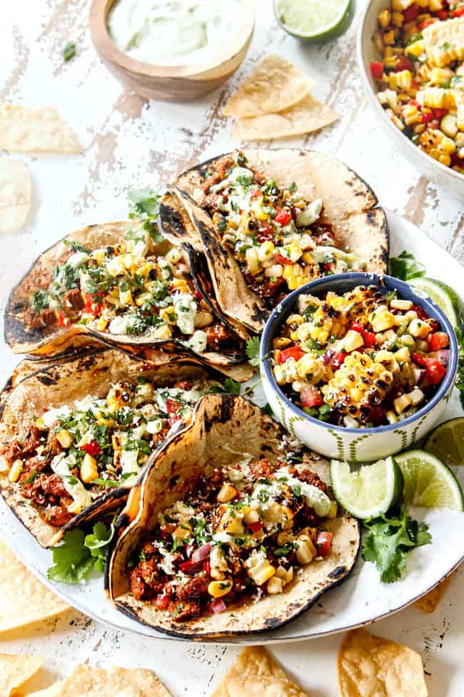 tacos de cerdo auténticos en un plato blanco con aderezos