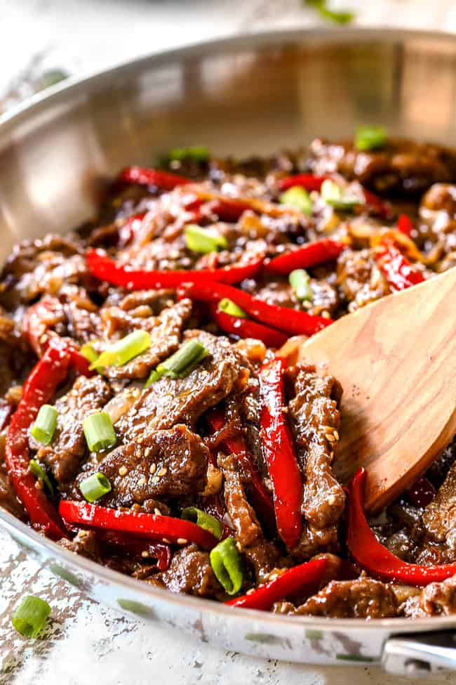 showing how to make Szechuan Beef y stir frying beef with bell peppers 