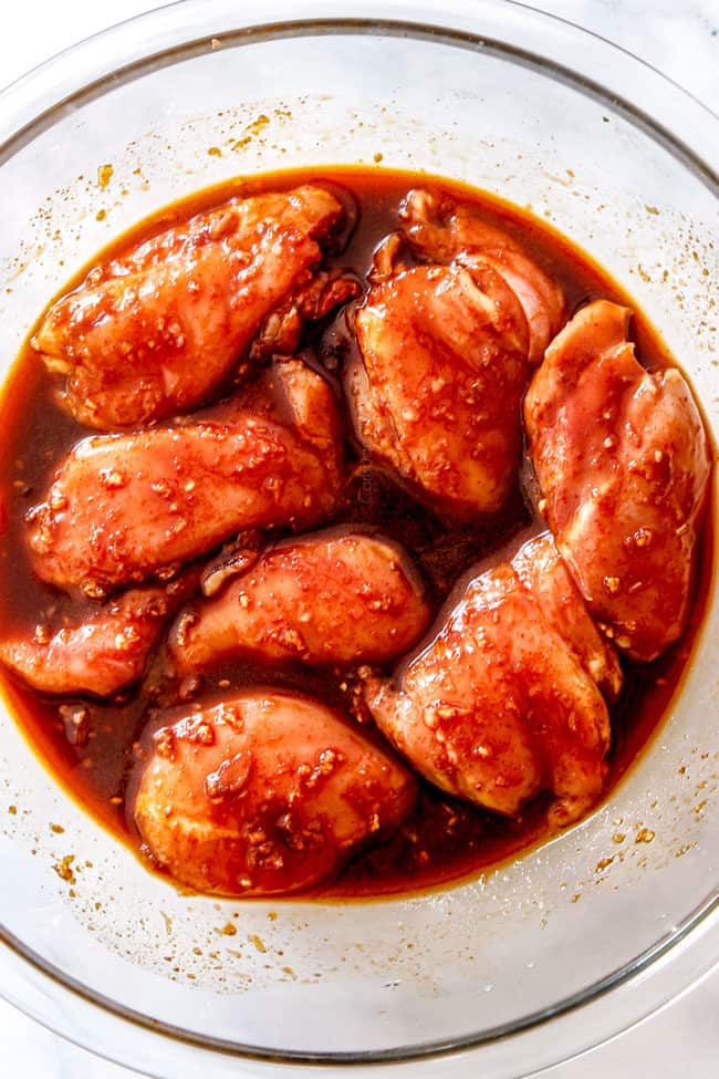 showing how to make Korean Chicken recipe by adding chicken to marinade