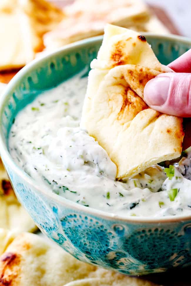 dipping pita bread into Greek Tzatziki 