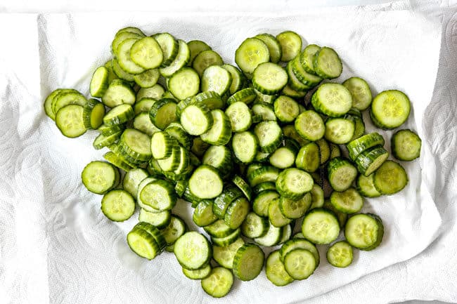showing how to make cucumber salad by drying cucumbers with paper towels