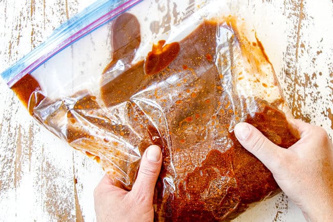 showing how to make carne asada recipe by massaging marinade into steak