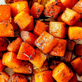 up close showing how to make roasted butternut squash recipe by stirring on baking sheet