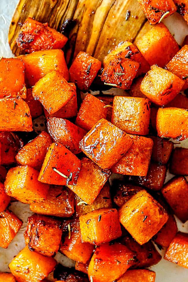 up close showing how to make roasted butternut squash recipe by stirring on baking sheet