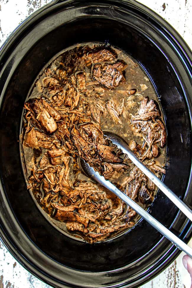 showing how to make Italian Beef recipe by shedding roast beef in crock pot for sandwiches