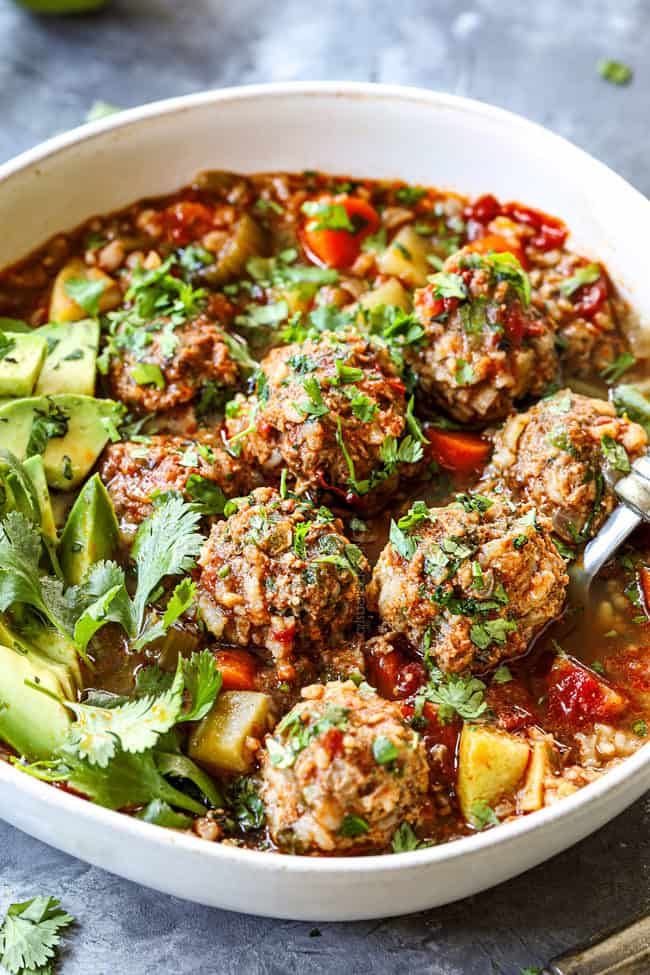 a spoon scooping up a meatball in authentic  Albondigas Soup
