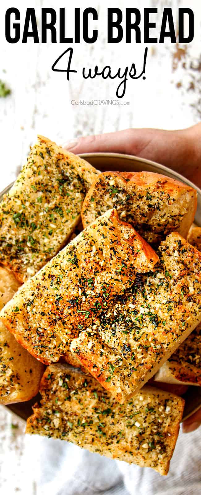 two hands holding a bowl of garlic bread in oven
