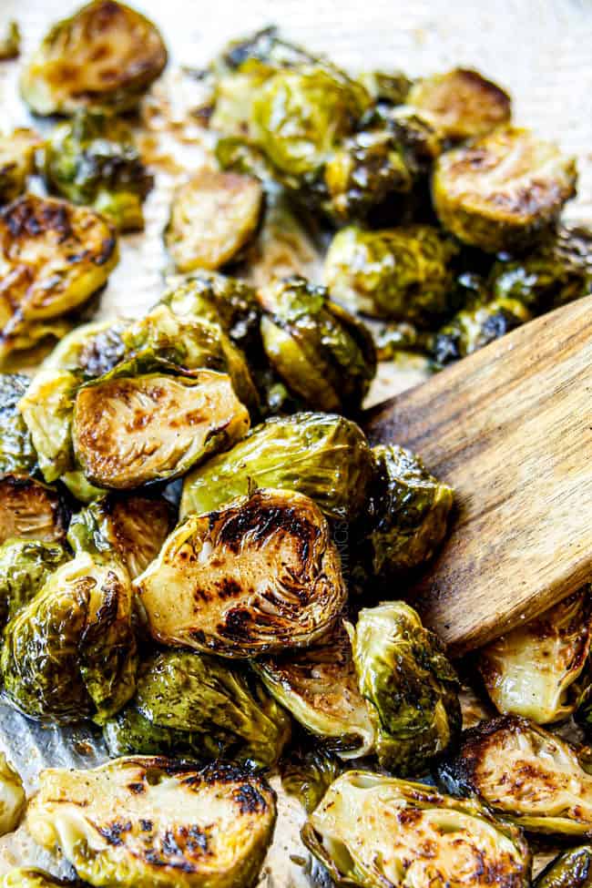 tossing Baked Brussels Sprouts on a baking sheet with salt and pepper