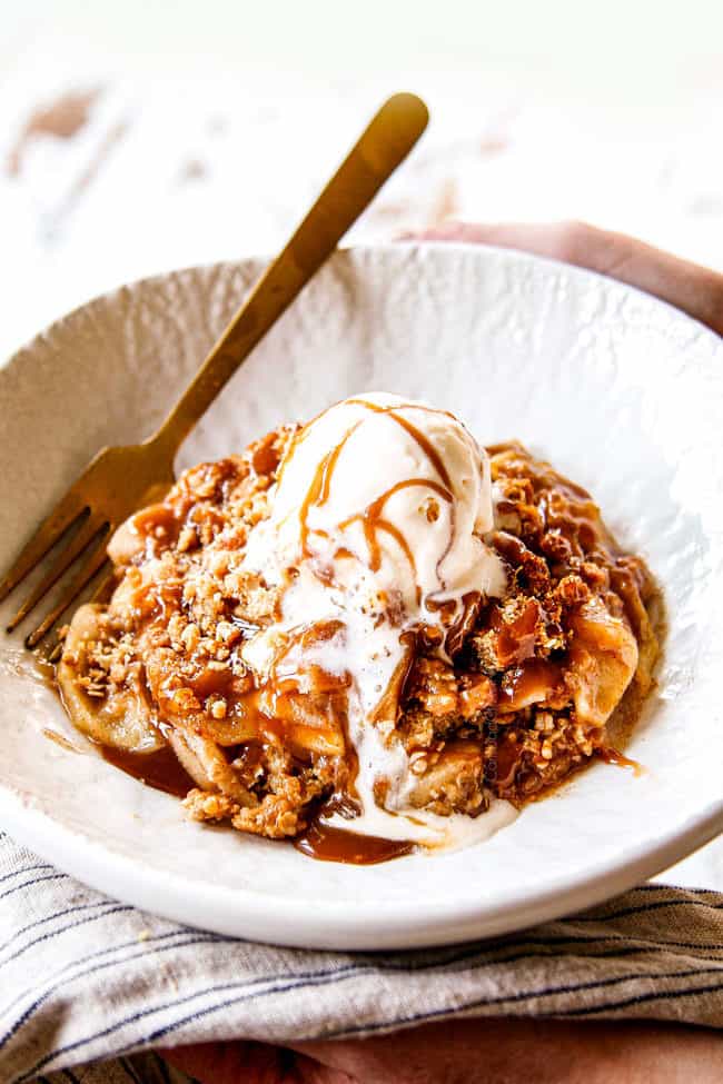 showing how to serve easy apple crisp recipe with oatmeal topping in a white bowl with ice cream and caramel