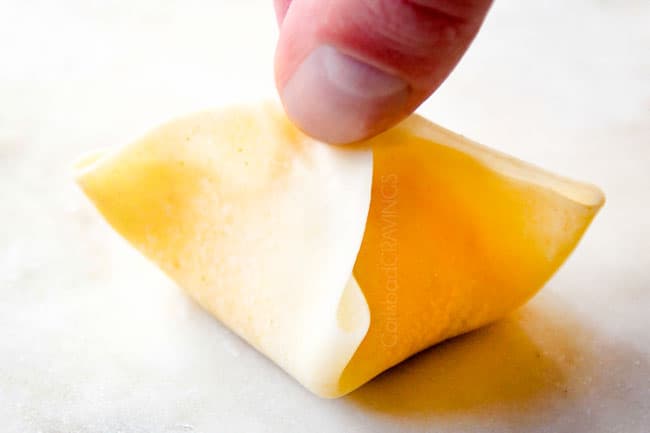 showing how to make crab rangoon by bringing all corners together