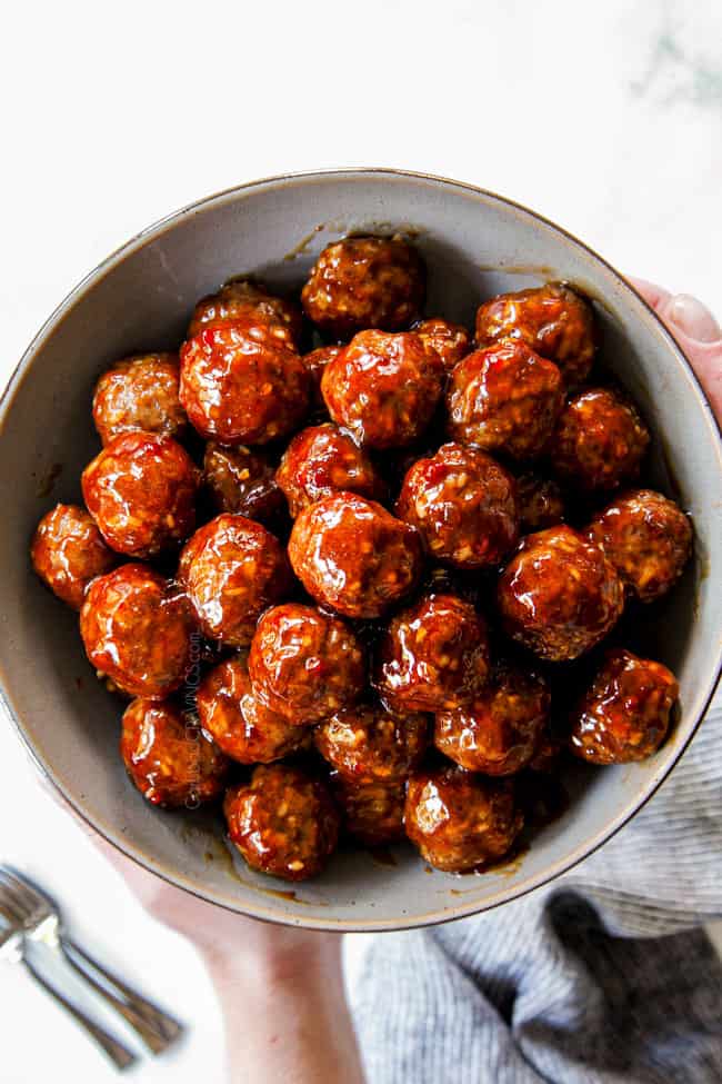 two hands holding a bowl of best cocktail meatball recipe