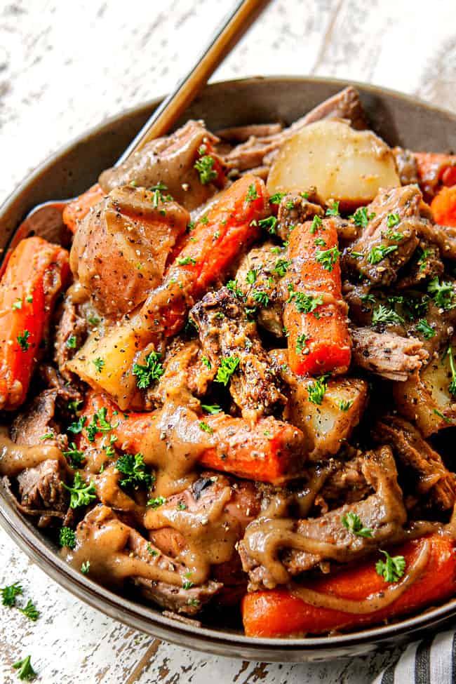 up close of a bowl of best crock pot pot roast made with chuck roast, carrots and potatoes