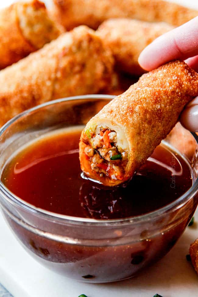 showing how to serve Chinese egg rolls by dipping into dipping sauce