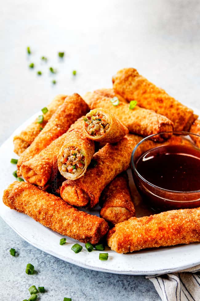 showing how to serve easy egg roll recipe by lining egg rolls on a plate with dipping sauce