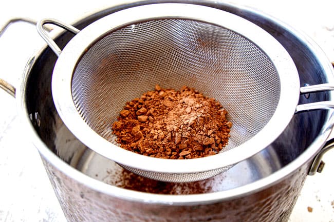 showing how to make homemade hot chocolate recipe by sifting in cocoa powder