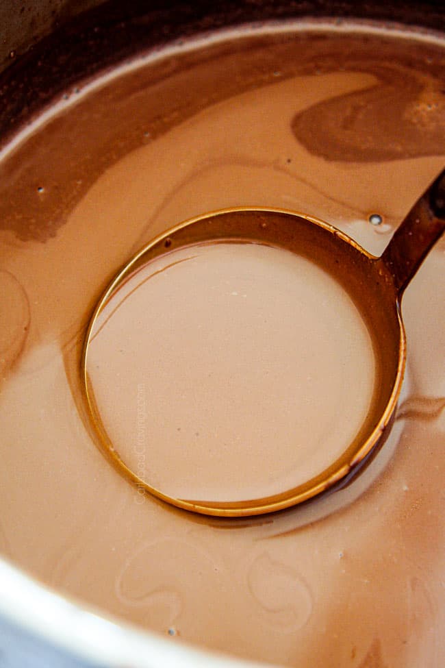 showing how to make homemade hot chocolate recipe by stirring chocolate chips until melted