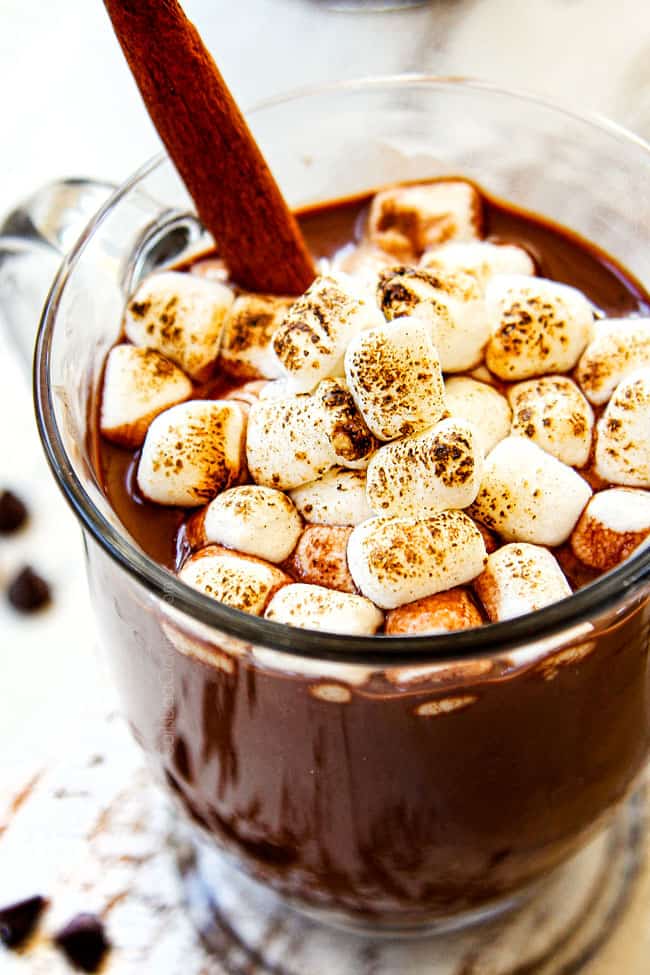 showing how to serve hot chocolate recipe by adding a cinnamon stick