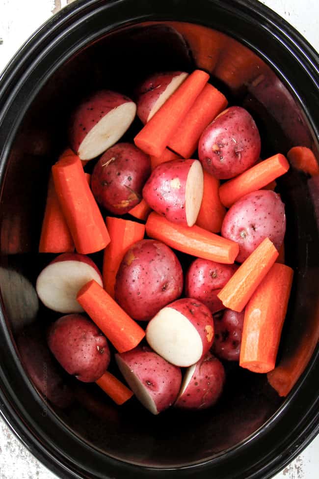 showing how to cook a roast in a crock pot by adding potatoes and carrots to the bottom of a slow cooker