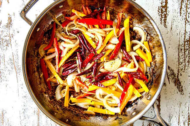 showing how to make Szechuan chicken by stir frying bell peppers, onions and Thai chili peppers