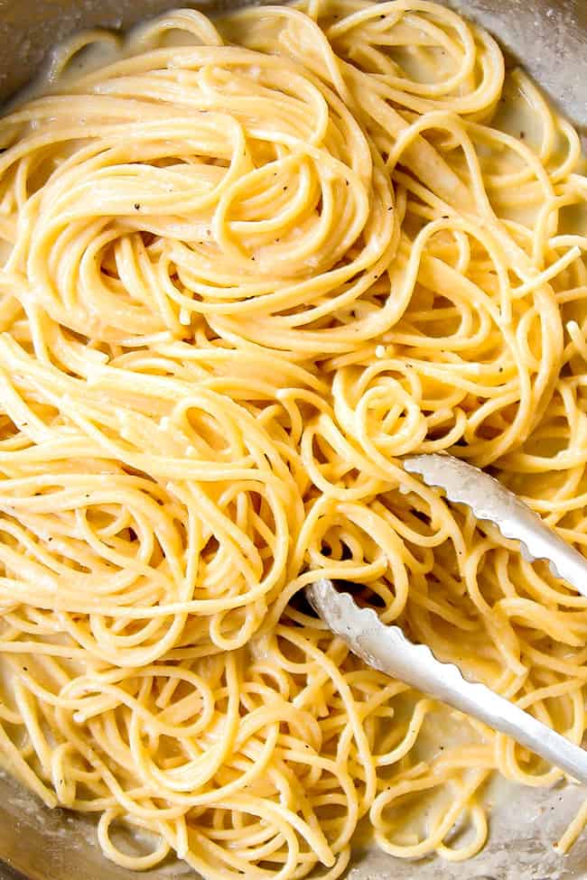 showing how to make Cacio e Pepe by stirring pasta until evenly coated in sauce