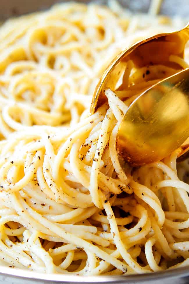 up close of spaghetti cacio e pepe recipe garnished with freshly cracked pepper showing how creamy the pasta is