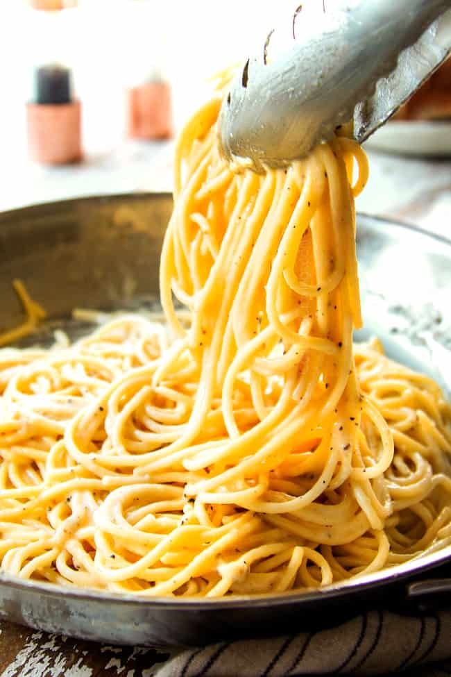 showing how to serve cacio e pepe recipe by picking up pasta with tongs