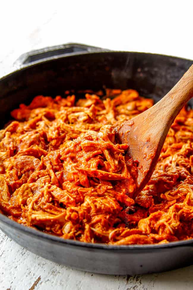 showinig how to make chicken tinga recipe by simmering chicken in tomato chipotle sauce