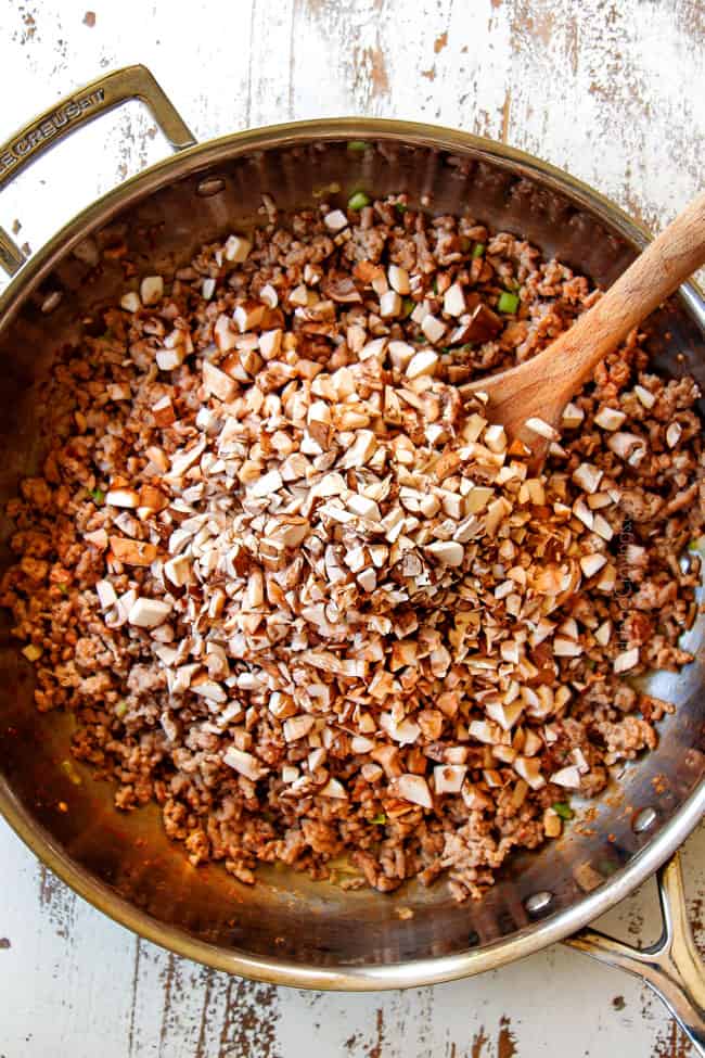showing how to make Egg Roll in a Bowl by adding chopped mushrooms to pork in a skillet