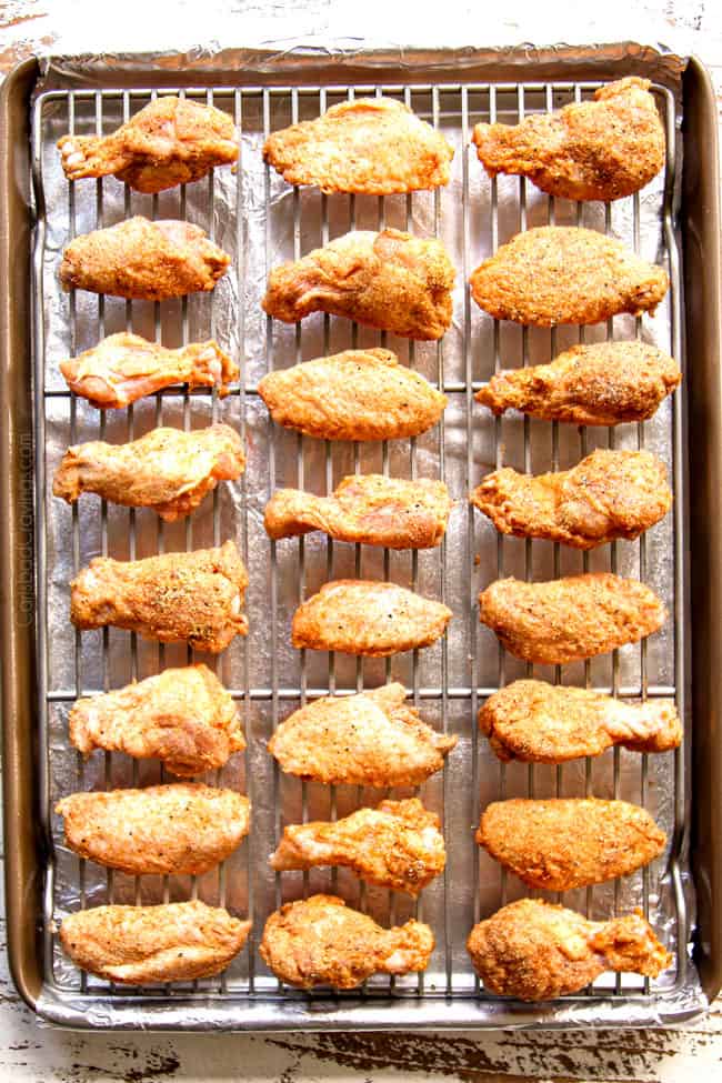 showing how to make lemon pepper chicken wings by lining spice rubbed wings on a baking rack