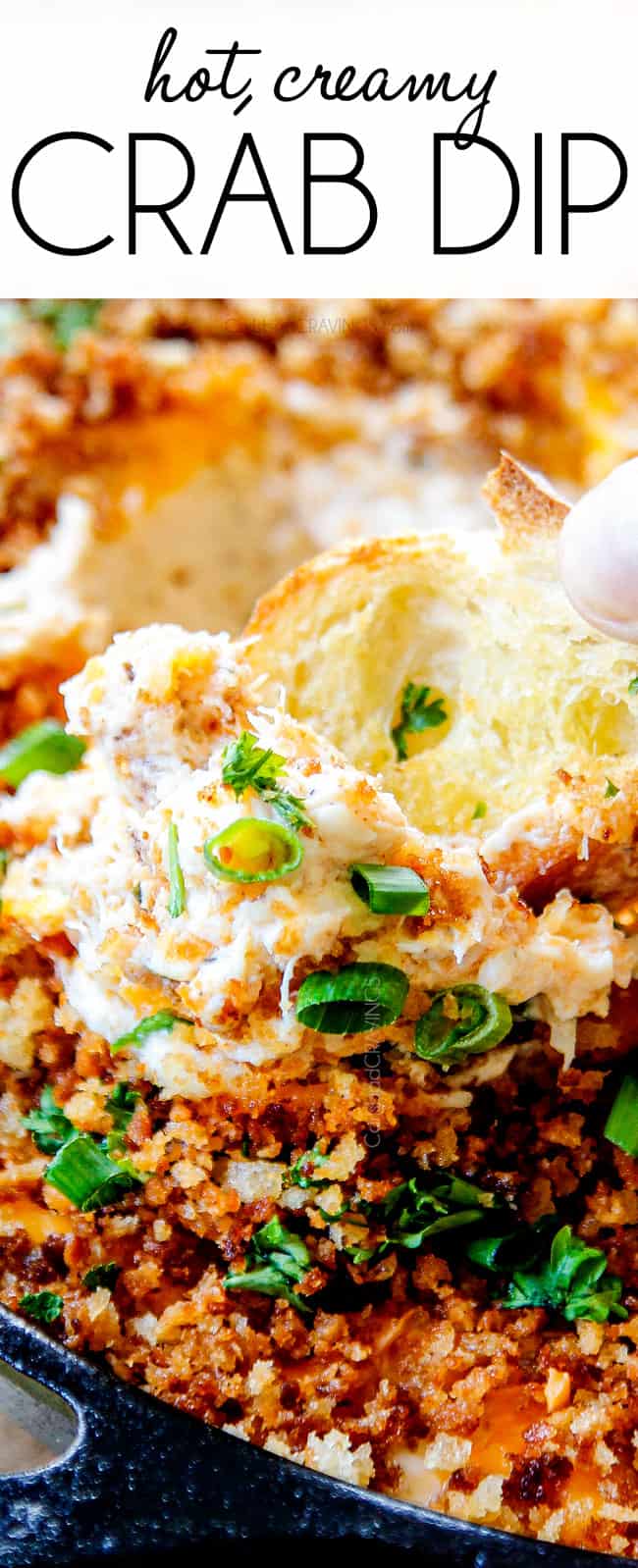 up close of serving hot crab dip recipe by scooping dip up with bread