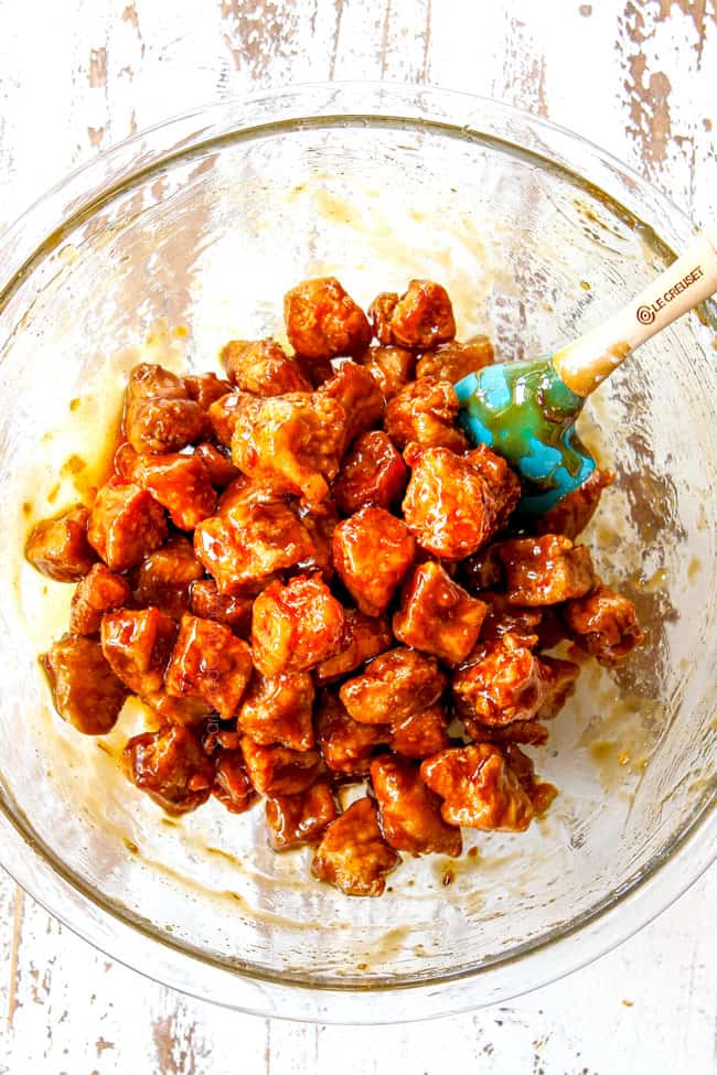 top view showing how to make healthy orange chicken by tossing breaded chicken in orange sauce