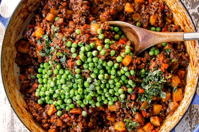showing how to make Picadillo Beef recipe by adding peas and fresh cilantro to cooked beef and potatoes