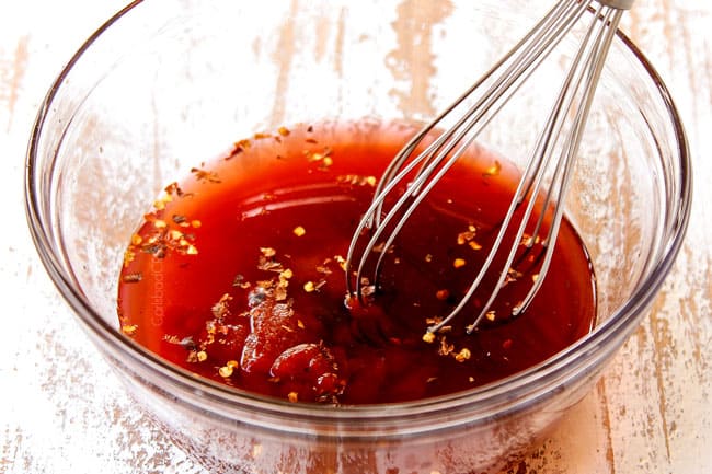 showing how to make sweet and sour chicken by whisking red wine  vinegar, sugar, pineapple juice and ketchup together to make sweet and sour sauce