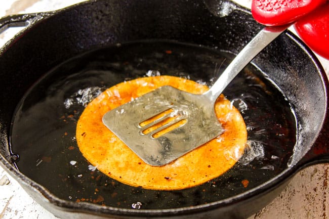 showing how to fry tostada shells by submerging in oil with a spatula