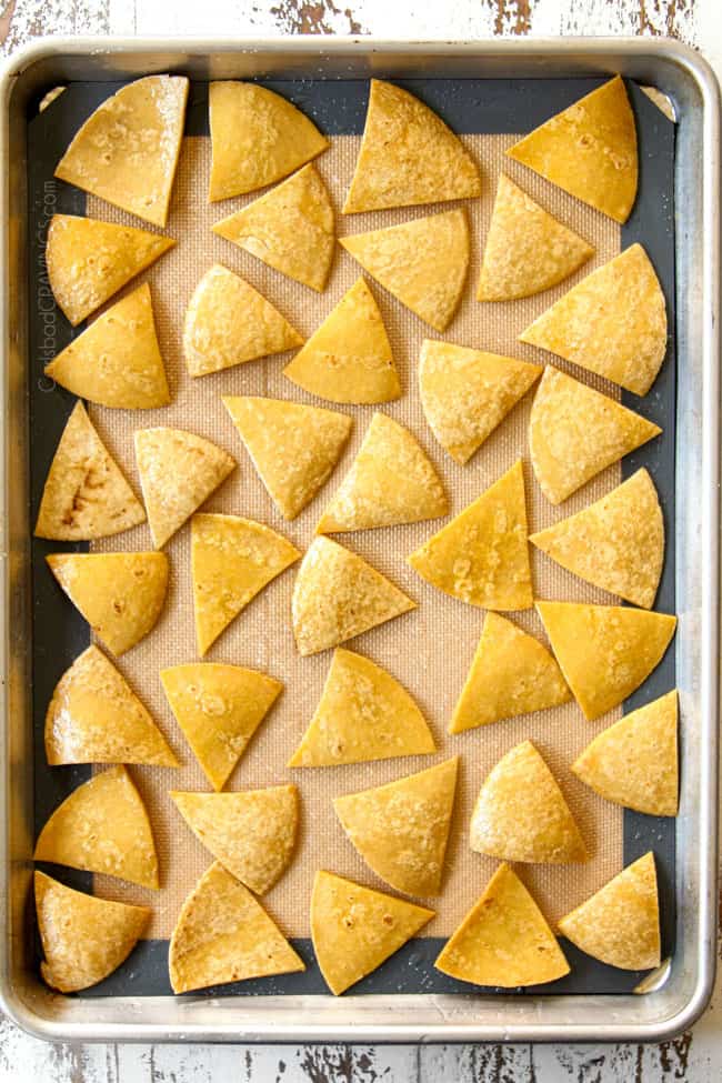 showing how to make Chilaquiles by spreading tortillas into a single layer on a baking sheet