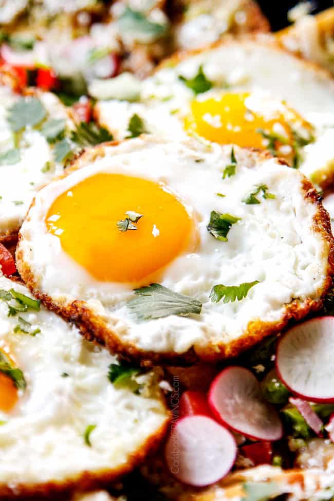 showing how to make Chilaquiles with Fried Eggs by frying eggs until golden around the edges
