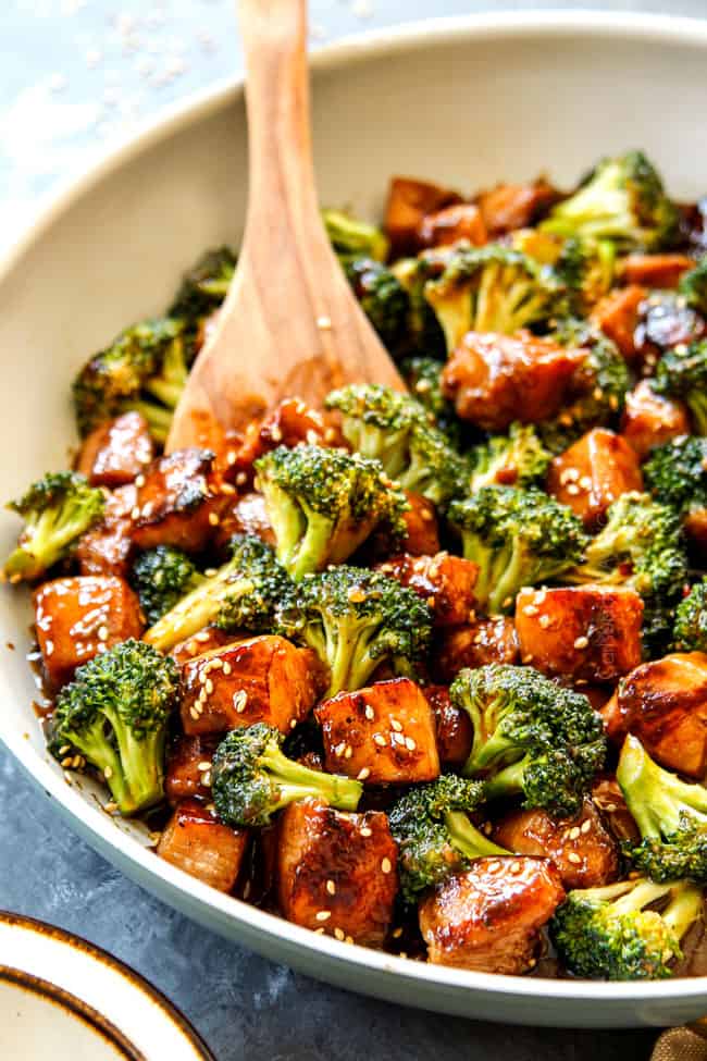 up close of showing how to garnish Chinese Chicken and Broccoli with sesame seeds
