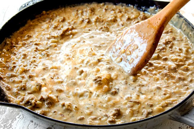 showing how to make ground beef stroganoff by stirring in cream cheese and sour cream until melted and the sauce is creamy