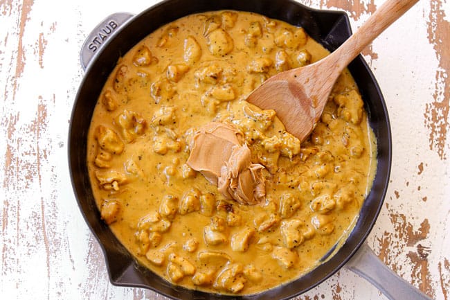 showing how to make peanut butter chicken by stirring in peanut butter