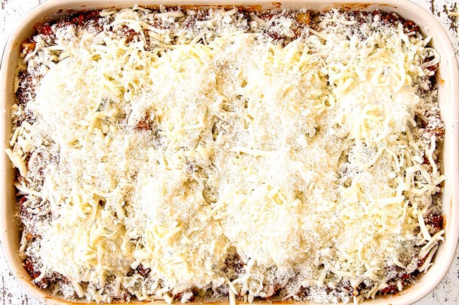 showing how to make easy Baked Ziti with ricotta, Italian sausage and meat by topping with remaining mozzarella and Parmesan