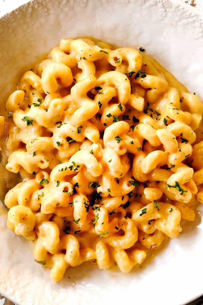 showing how to serve stovetop homemade mac and cheese by adding to a  white bowl