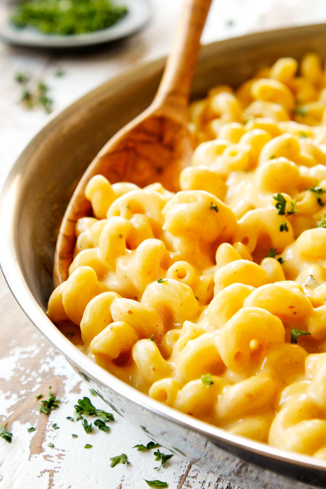 showing how to make best mac and  cheese by stirring pasta into cheese sauce until combined 