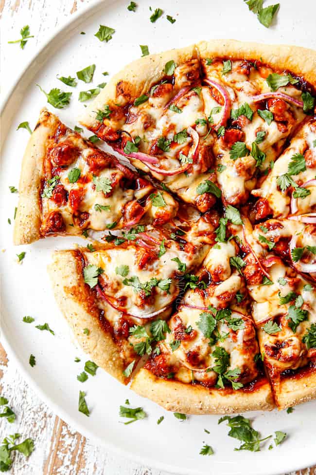 top view or BBQ Chicken Pizza by on a white platter garnishing with cilantro