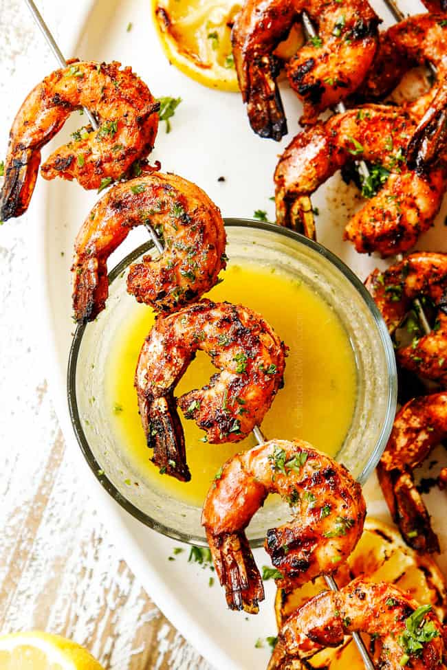 showing how to make grilled shrimp recipe by combing melted butter with lemon and parsley and serving with shrimp