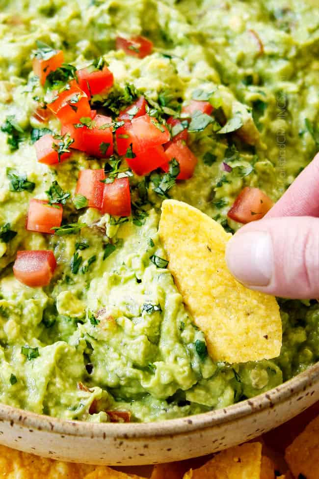 showing how eat guacamole recipe by scooping it up with a tortilla chip